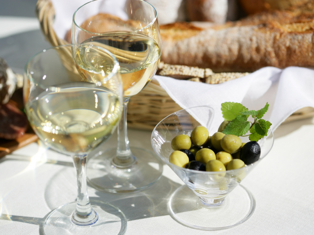 Zwei Weingläser mit Oliven und Baguette auf einem Tisch – Apéro-Teamevent in der La Cookerie Kochschule Ingolstadt